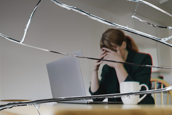 Stressed woman sitting in front of laptop with cracked glass eff Mujer estresada enfrente del portatil