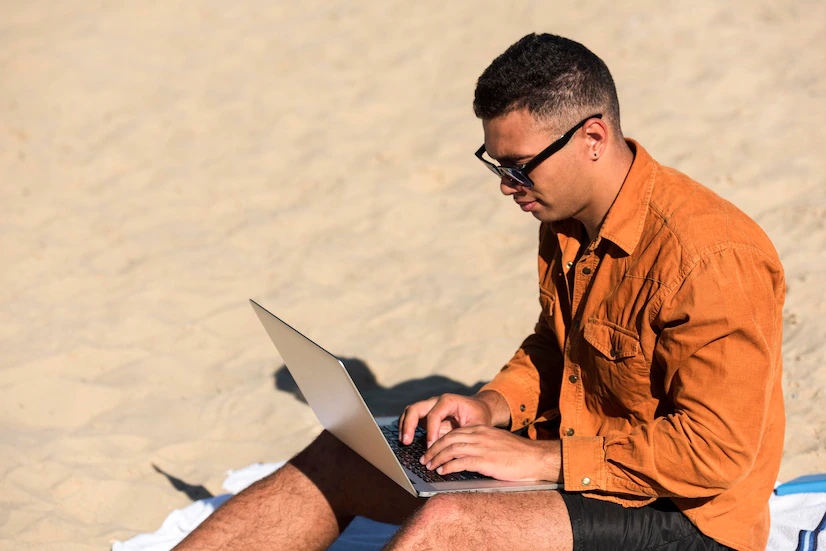 hombre con portatil en la playa